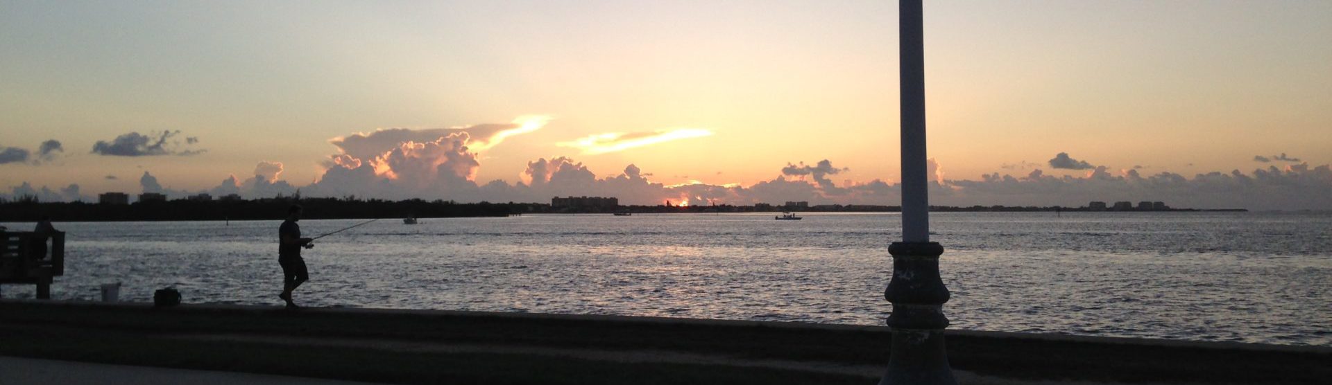 Silhouette of a fisherman in front of a sunset